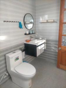 ein Badezimmer mit einem weißen WC und einem Waschbecken in der Unterkunft Ly's homestay in Gia Nghĩa