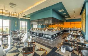 a restaurant with a bar and tables and chairs at La Vela Hue Hotel in Hue