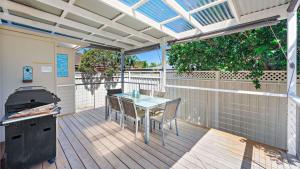 un patio con mesa, sillas y parrilla en Harrys Pet Friendly Holiday House en Nelson Bay