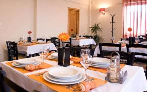 a dining room with white tables and black chairs at Pension Panorama in Odorheiu Secuiesc