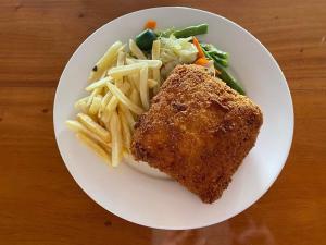 a plate of food with a fish and french fries at Tongatok Cliff Resort in Mambajao