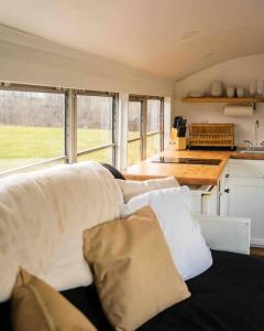 un sofá con almohadas en la cocina en Serene Bus Getaway Among Rolling Farm Land en Granville