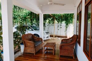 a porch with two chairs and a table and a car at Cozy private villa in Fukuchani in Mchangani
