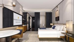een hotelkamer met een bed en een televisie bij InterContinental Ningbo, an IHG Hotel in Ningbo