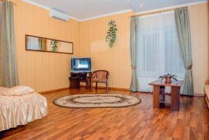 a room with a bed and a table and a television at Hotel Vivat Provincia in Takhtaulove