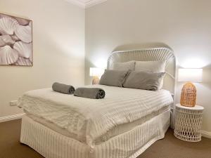 a bedroom with a white bed with two pillows on it at Stays on Main in Narrabri