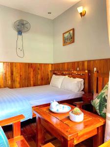 a hotel room with two beds and a table with at Liên tho Phú Quốc in Phu Quoc