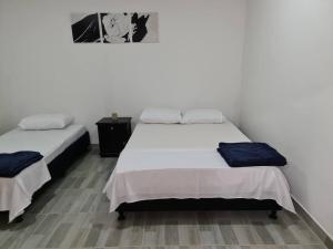 two beds in a room with white walls at Apartamento donde Alicia in La Tebaida