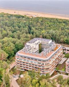 Cette chambre offre une vue sur un grand bâtiment situé à côté d'une plage. dans l'établissement Lividus Czarna Mewa, à Świnoujście