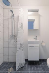 a bathroom with a shower curtain and a sink at Posti Guesthouse in Rakvere