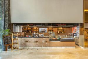 a restaurant with a counter and stools in a room at MORAZEN Surabaya in Surabaya