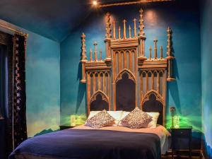um quarto com uma cama grande e uma cabeceira em madeira em Queen Mabs-uk42999 em Upper Helmsley