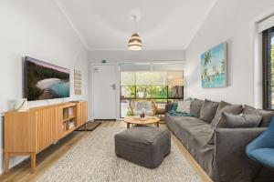 una sala de estar con un sofá y una mesa en Orion Retreat by Experience Jervis Bay, en Vincentia