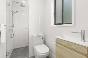Un baño con inodoro, ducha y lavabo. en Orion Retreat by Experience Jervis Bay, en Vincentia 9 fotos más