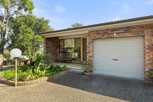 una casa de ladrillo con una puerta de garaje delante de ella en Orion Retreat by Experience Jervis Bay, en Vincentia
