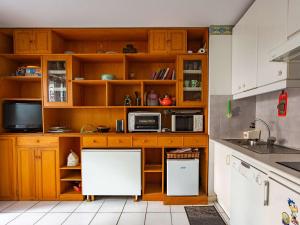 - une cuisine avec des placards en bois et un réfrigérateur blanc dans l'établissement Appartement Hendaye, 2 pièces, 4 personnes - FR-1-2-418, à Hendaye