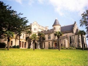 a large castle with palm trees in front of it at Appartement RDC avec terrasse, piscine et parking à 1km de la plage - FR-1-2-418 in Hendaye