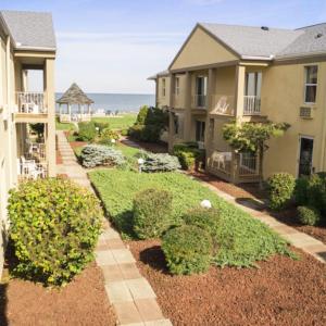 a house with a garden in front of the ocean at Clinton Inn & Suites in Port Clinton