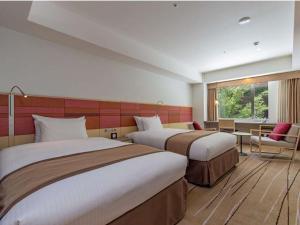 a hotel room with two beds and a window at JR Kyushu Hotel Blossom Hakata Central in Fukuoka