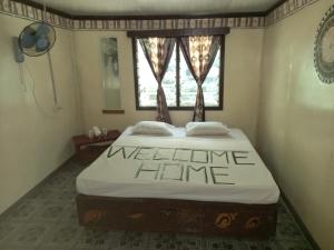 ein Schlafzimmer mit einem Bett mit einem Willkommensschild darauf in der Unterkunft WAI MAKARE HOMESTAY ROOM 2 in Naviti Island