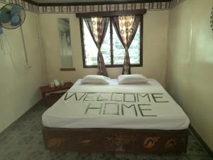 a bedroom with a bed with a welcome time sign on it at WAI MAKARE HOMESTAY ROOM 2 in Naviti Island