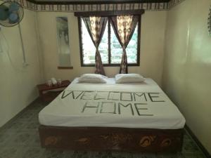 a bed in a room with a welcome home sign on it at WAI MAKARE HOMESTAY ROOM 2 in Naviti Island