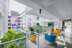 a balcony with colorful chairs and tables in a building at Viva Dash Hotel Seminyak in Seminyak