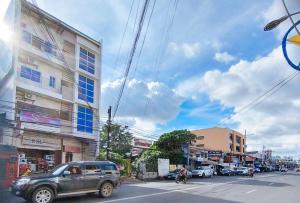 RedDoorz @ RSL Transient House Iloilo في إيلويلو سيتي: a truck driving down a street in a city