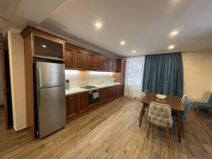 a large kitchen with a table and a refrigerator at Villa Rodonson in Bakuriani