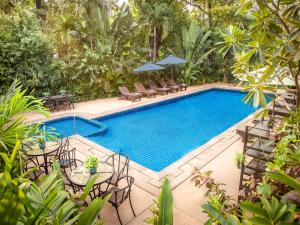 a swimming pool with chairs and a table next to a resort at Chateau d'Angkor La Residence in Siem Reap