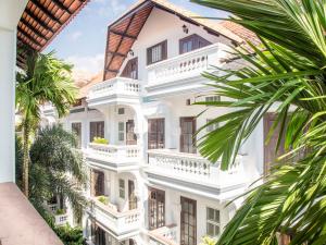 a white building with balconies and palm trees at Chateau d'Angkor La Residence in Siem Reap