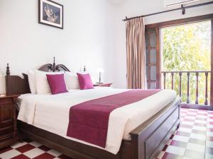 a bedroom with a large bed and a balcony at Chateau d'Angkor La Residence in Siem Reap