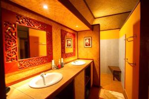 een badkamer met 2 wastafels en een spiegel bij Old Tree's House ThaTon in Mae Ai