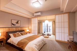 a bedroom with a large bed and a television at Chuan House Dotonbori in Osaka
