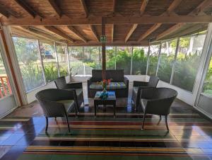un porche cubierto con sillas y mesa en Capi´s Place en San Andrés