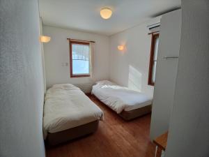 1 dormitorio con 2 camas y ventana en Pension Gooseberry, en Furano