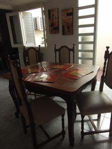 una mesa de madera y sillas en una habitación en Casa Mariclaire en Bahía Blanca