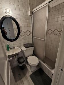 y baño con aseo, lavabo y ducha. en Suite Doble en Parque la Carolina, en Quito