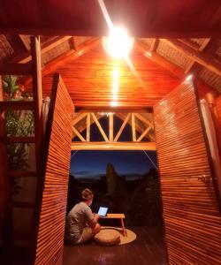 a person sitting in the inside of a tree house with a laptop at SMALL CABIN IN THE SOUTH 