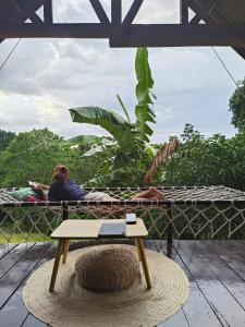 a woman laying on a deck with a table at SMALL CABIN IN THE SOUTH 