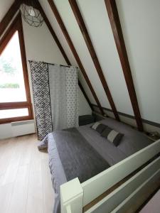 - une chambre mansardée avec un grand lit dans l'établissement Gite Delphine, à Kaysersberg
