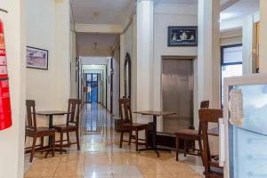 un pasillo con mesas y sillas en un edificio en Graha Ara Homestay Syariah RSUD Dr Soetomo Surabaya Mitra RedDoorz, en Surabaya