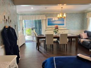 een eetkamer en een woonkamer met een tafel en stoelen bij House of Mahalo BnB in Mapleton