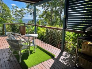 a patio with a table and chairs on a deck at House of Mahalo BnB in Mapleton