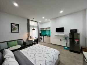 um quarto com uma cama, um sofá e uma cozinha em May Studio em Da Lat