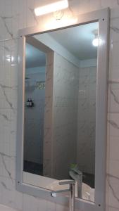 a mirror above a sink in a bathroom at Toraja Homestay & Coffee Bunna in Rantepao