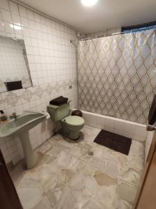 y baño con aseo, lavabo y ducha. en Dormitorio Amplio cerca de Parque Carolina, en Quito