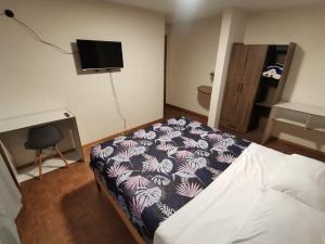 1 dormitorio pequeño con 1 cama y TV en Dormitorio Amplio cerca de Parque Carolina, en Quito