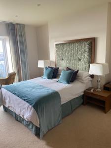 a bedroom with a large bed with blue pillows at Flat 3, Murray Crescent House in Milford Haven