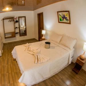 a large white bed in a room with two lamps at Evolução Ecolodge in Iranduba
